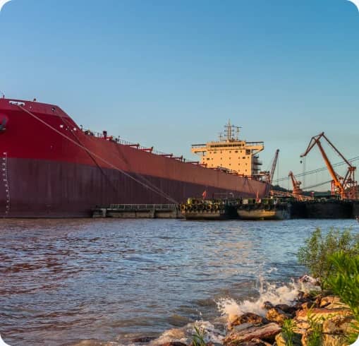 Bulk carrier ship moored at a river port with a crane alongside
