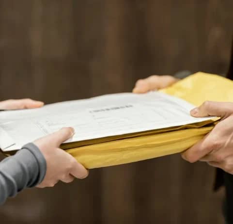 Shipping documents in an envelope being handed over