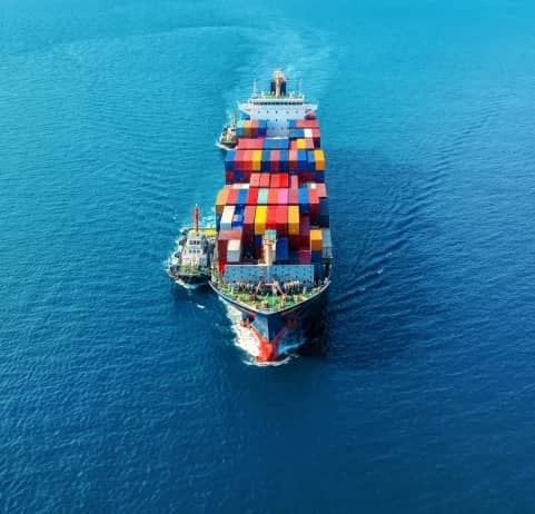 Aerial view of a fully loaded container ship sailing on open sea