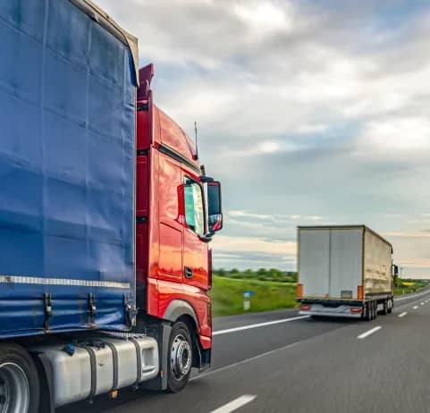 Red container trucks driving along a highway